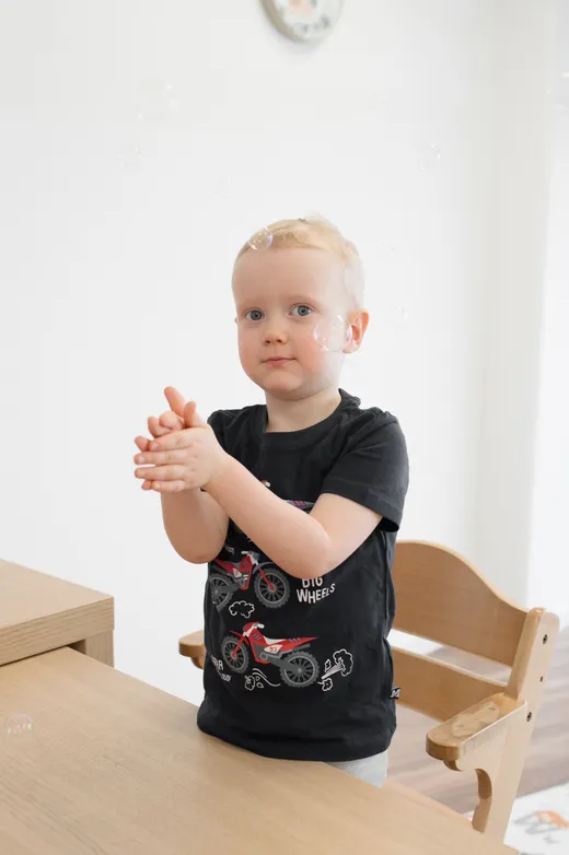 A young child using their hands to communicate during a session