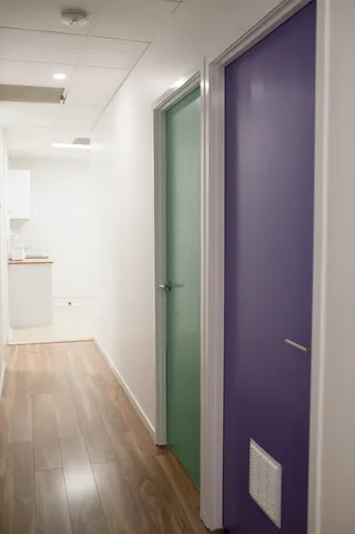 The hallway inside the Ashgrove clinic, with green and purple therapy room doors