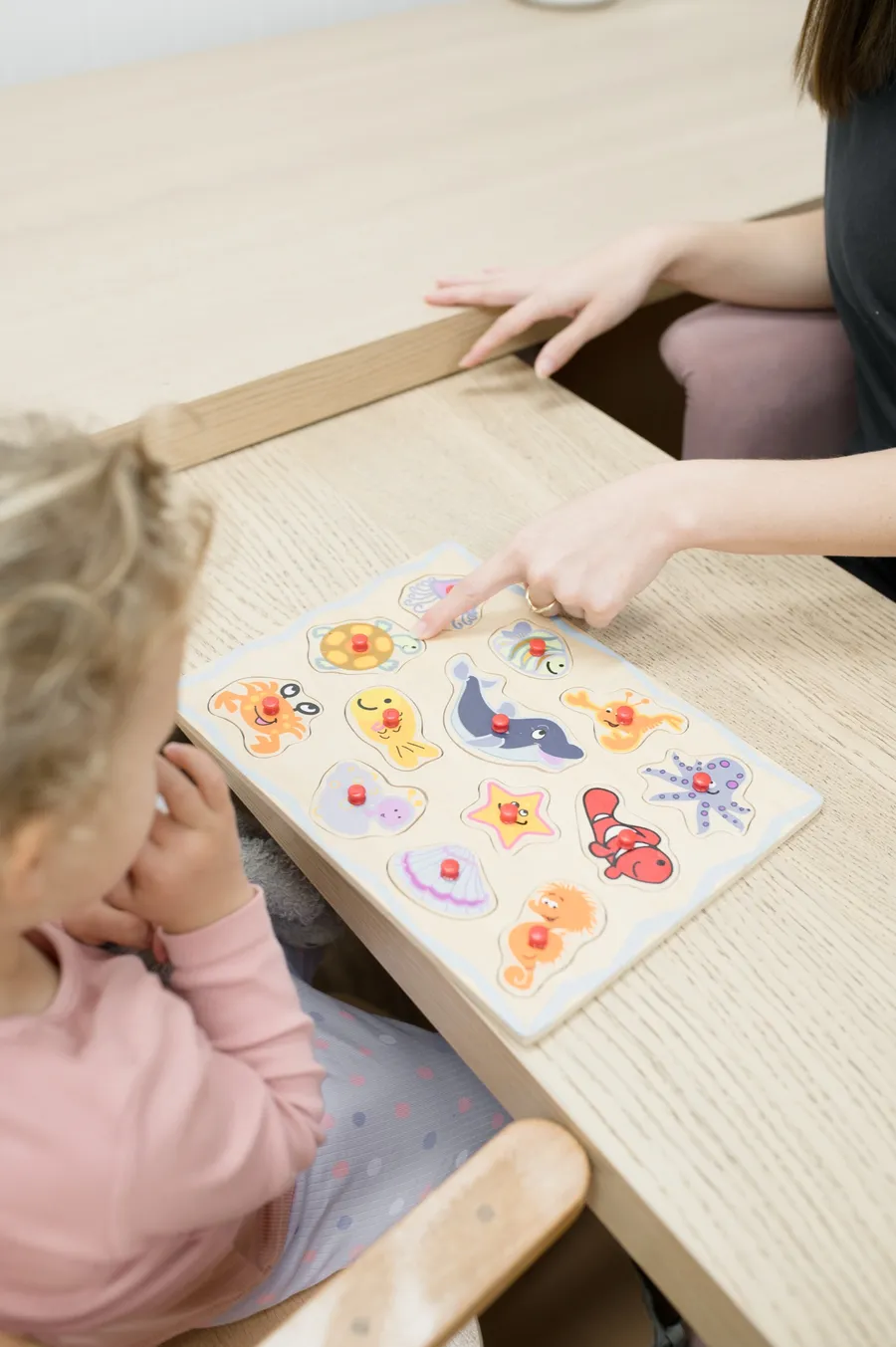 A speech pathologist and a child working through a picture activity together
