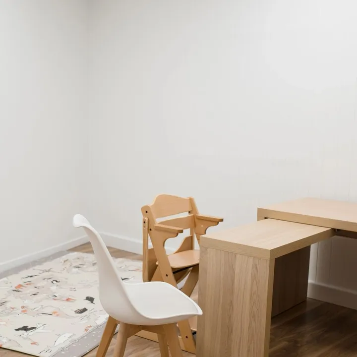 A bright therapy room at the Ashgrove clinic with a wooden table and child-sized chairs