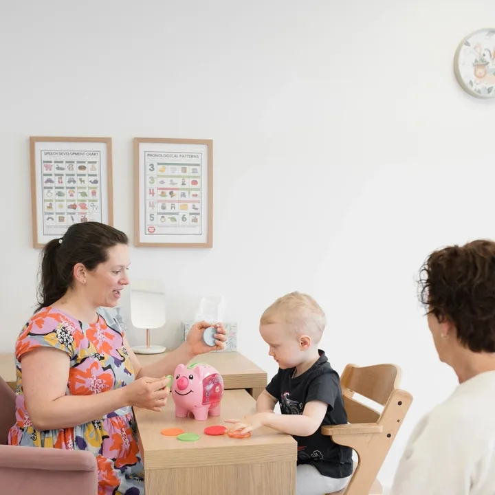 A speech pathologist working with a young child and their parent at the Ashgrove clinic